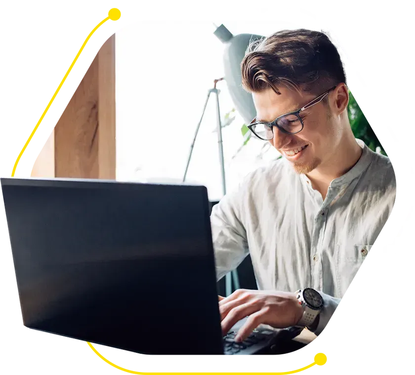 a man wearing glasses is typing on a laptop