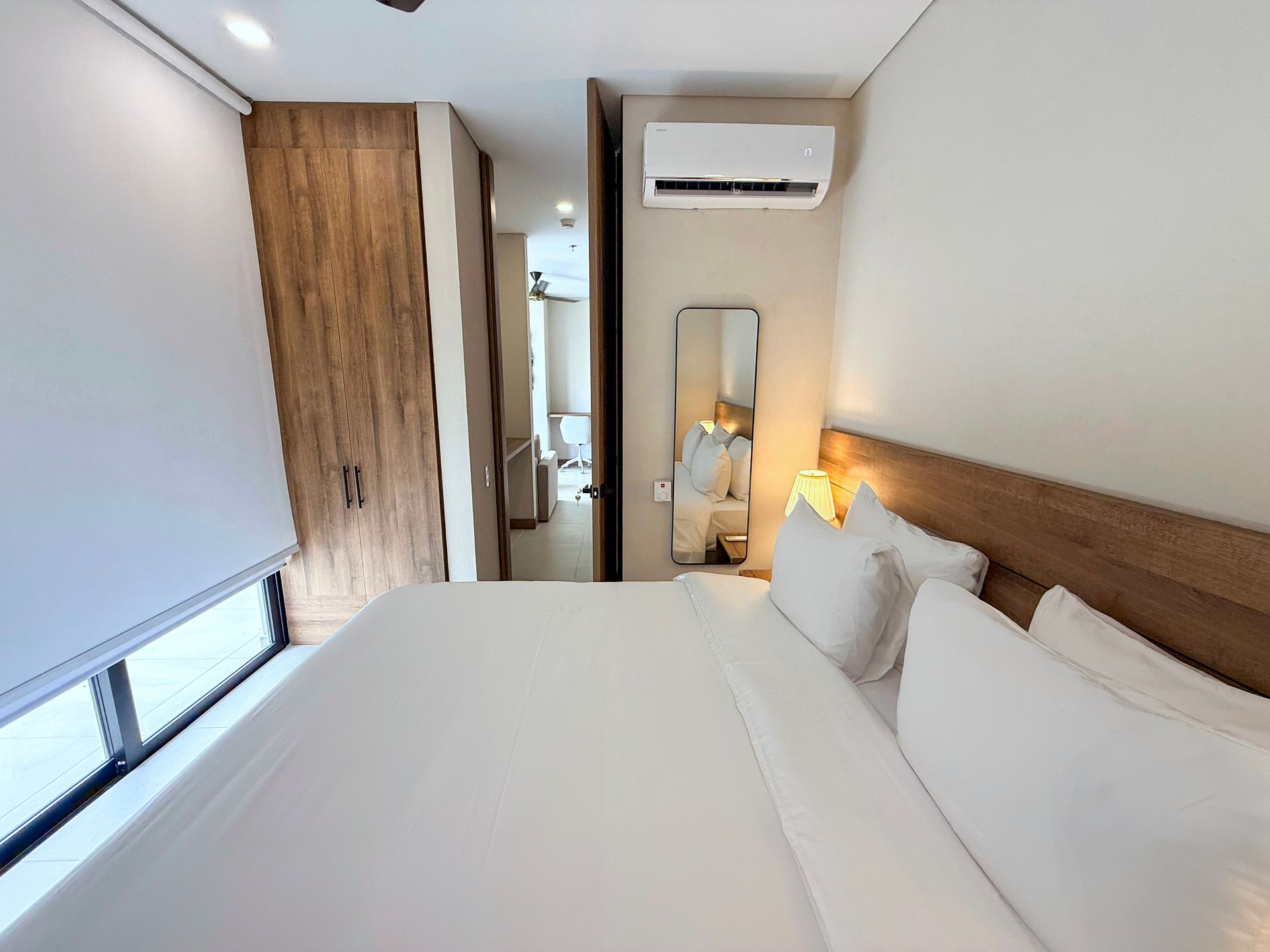 Habitación en hotel Bello Horizonte Santa Marta con cama king, cabecero de madera, lámparas, ventilador y aire acondicionado