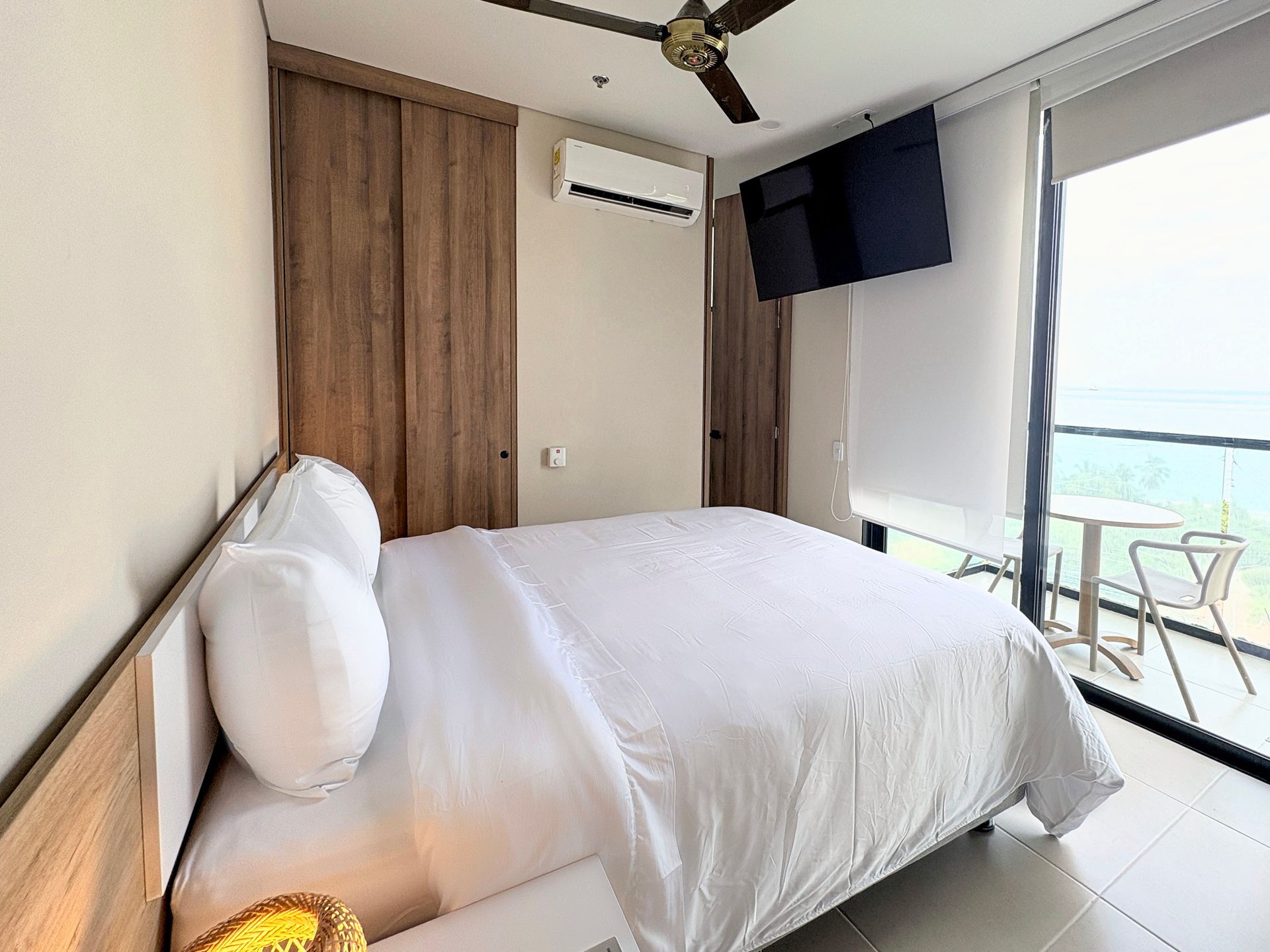 Habitación de Nuruma hotel en Bello Horizonte Santa Marta con cama king, cabecero de madera, lámpara y clóset