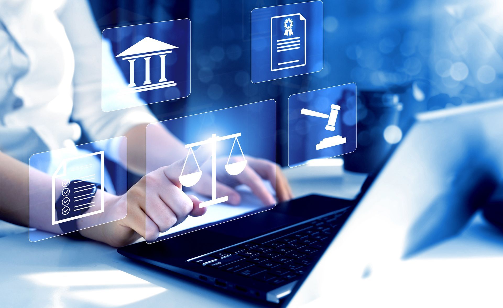 A person is typing on a laptop computer with a scale of justice coming out of it.