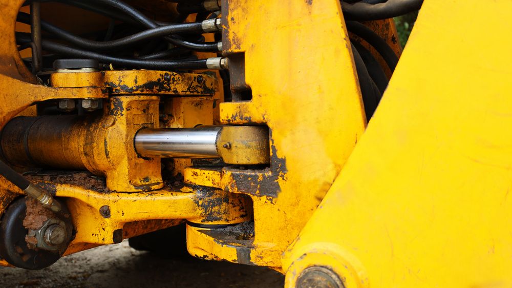 Yellow Hydraulic Cylinder on A Construction Vehicle — Berkeley Vale Hydraulics in Fountaindale, NSW