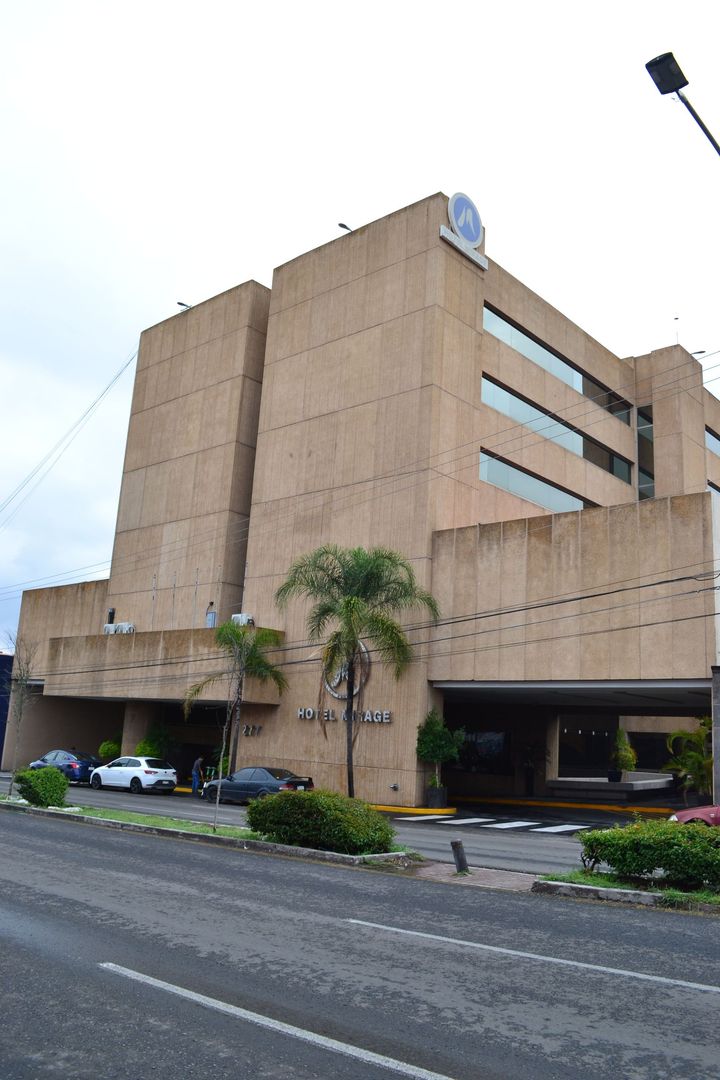 La fachada de un edificio de color beige, con un logotipo de HOTEL MIRAGE