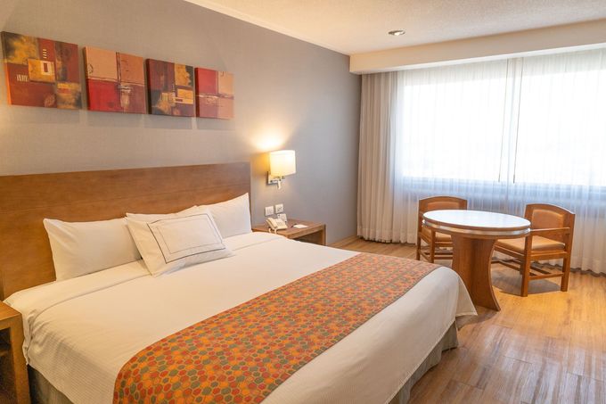 Una habitación de hotel con una cama tamaño queen,
