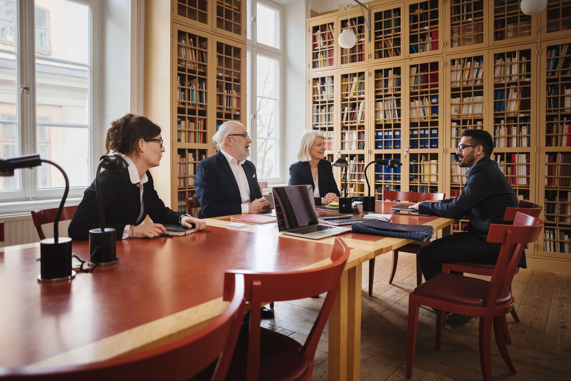 A group of people are sitting around a table in a library.