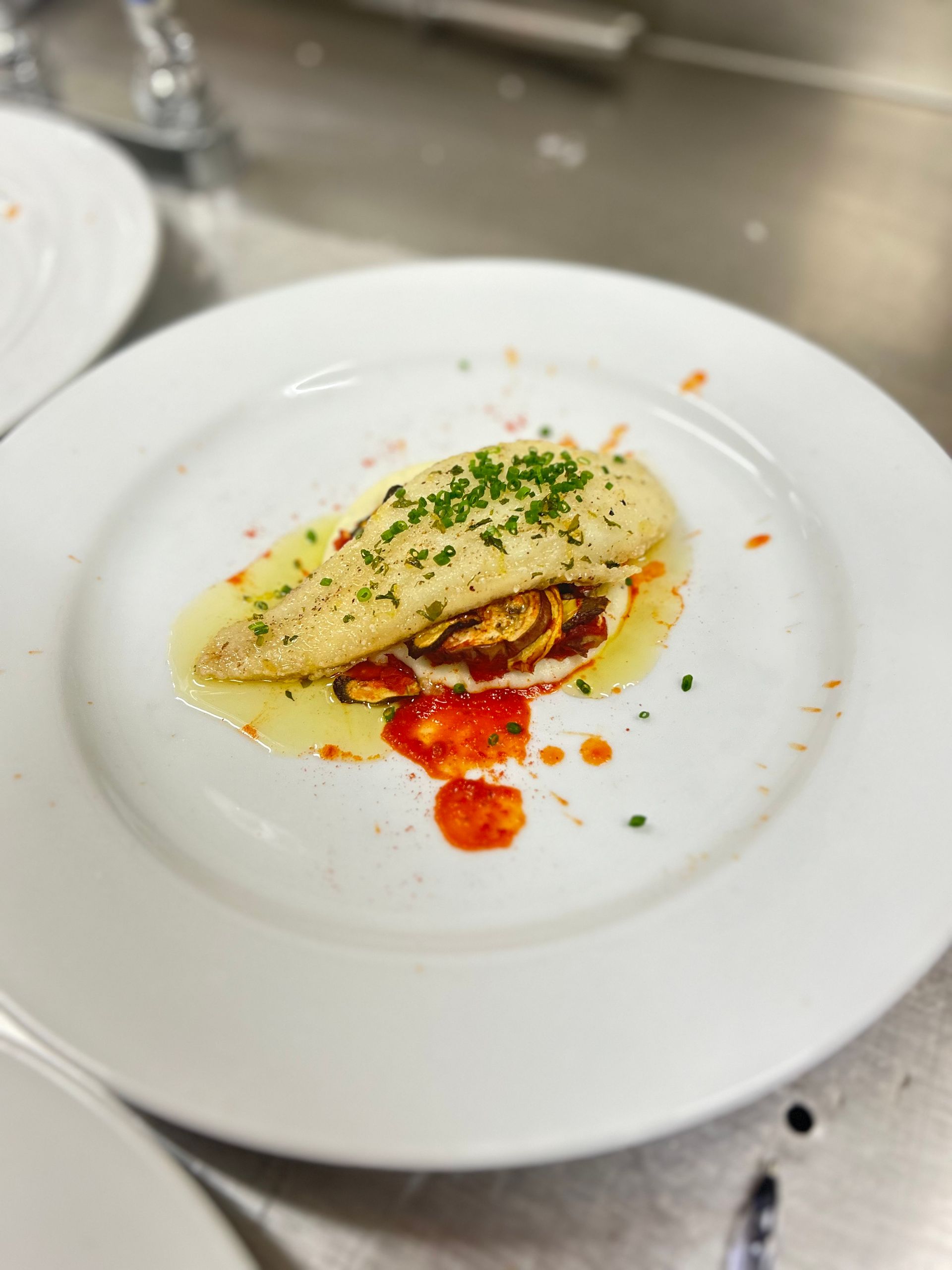 A white plate topped with a piece of food on a table.