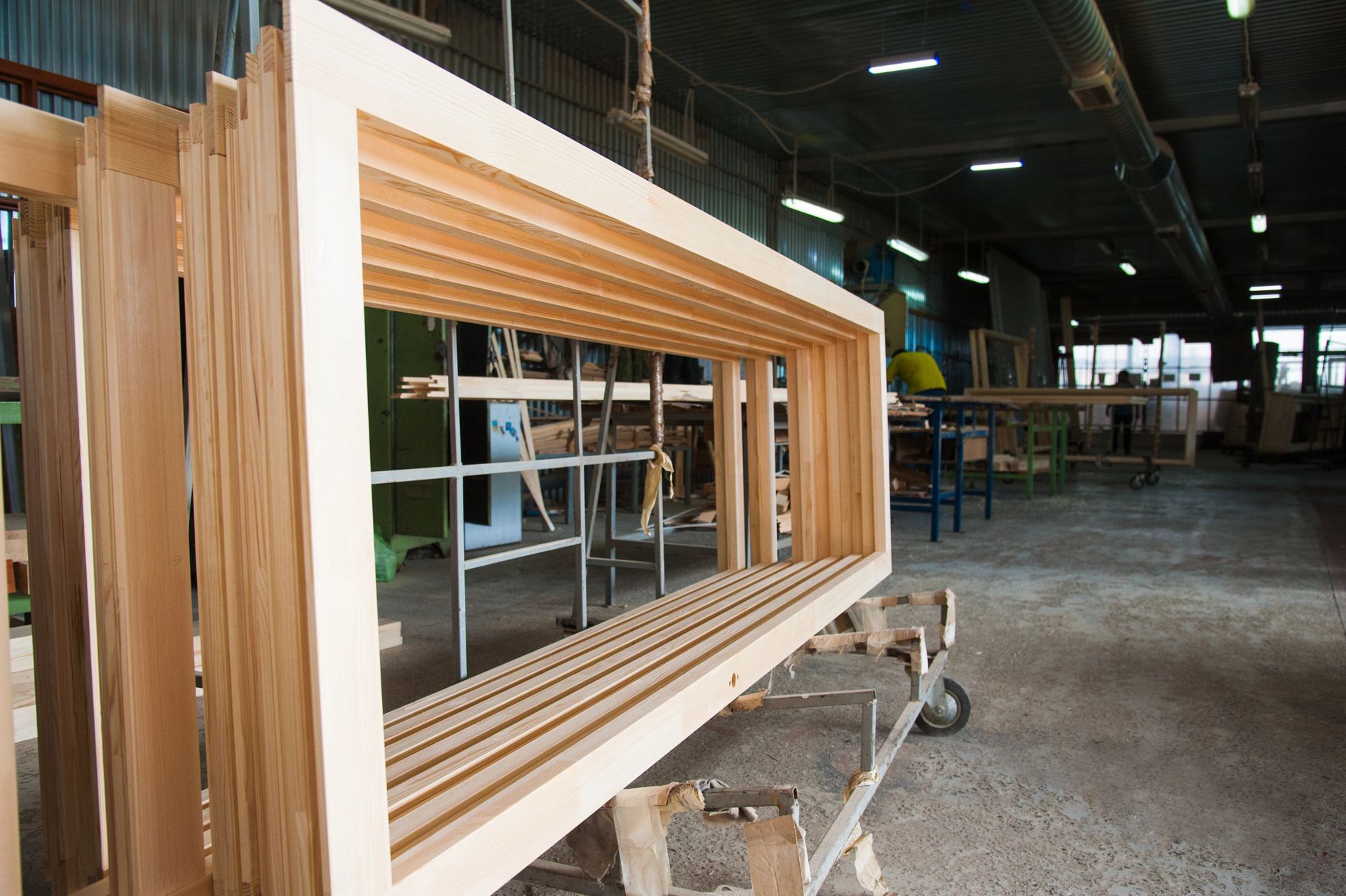 Telai di finestre in legno accatastati in un'officina.