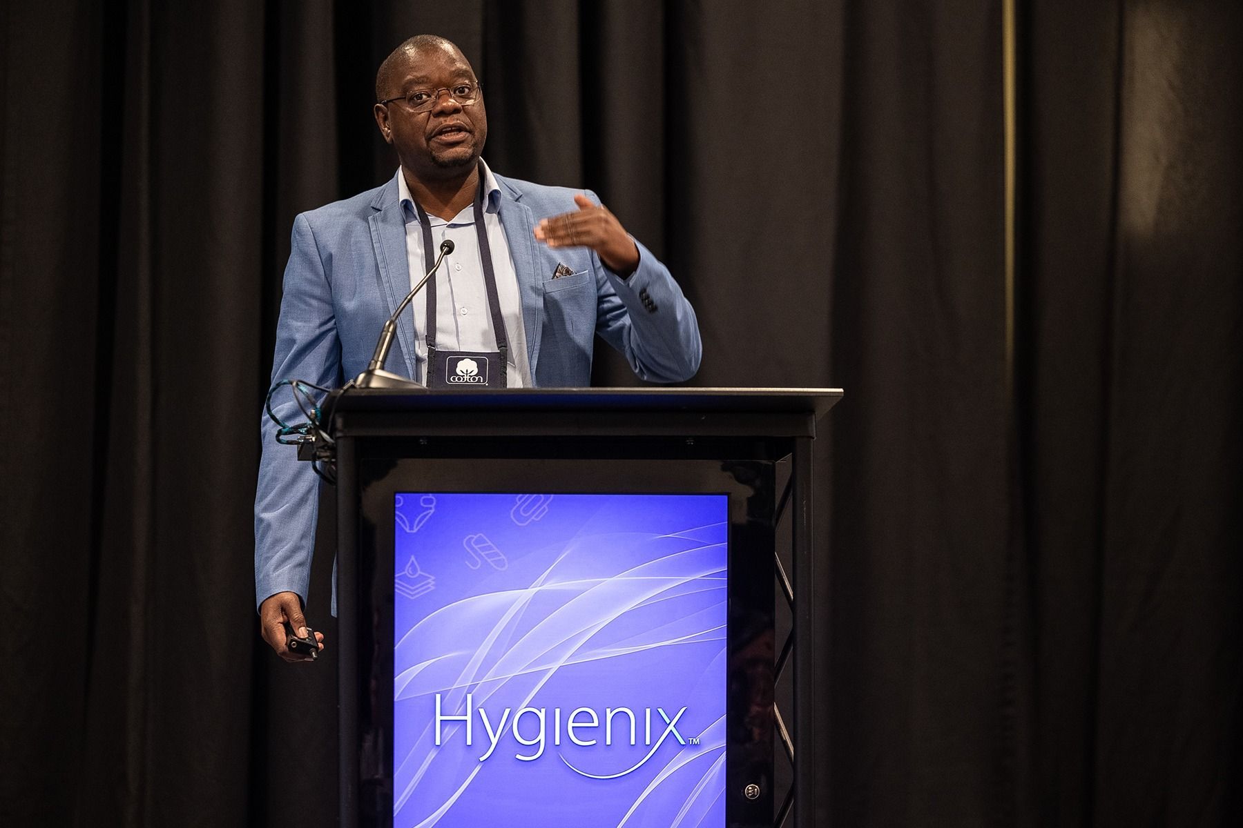 Man speaking at a podium with a 