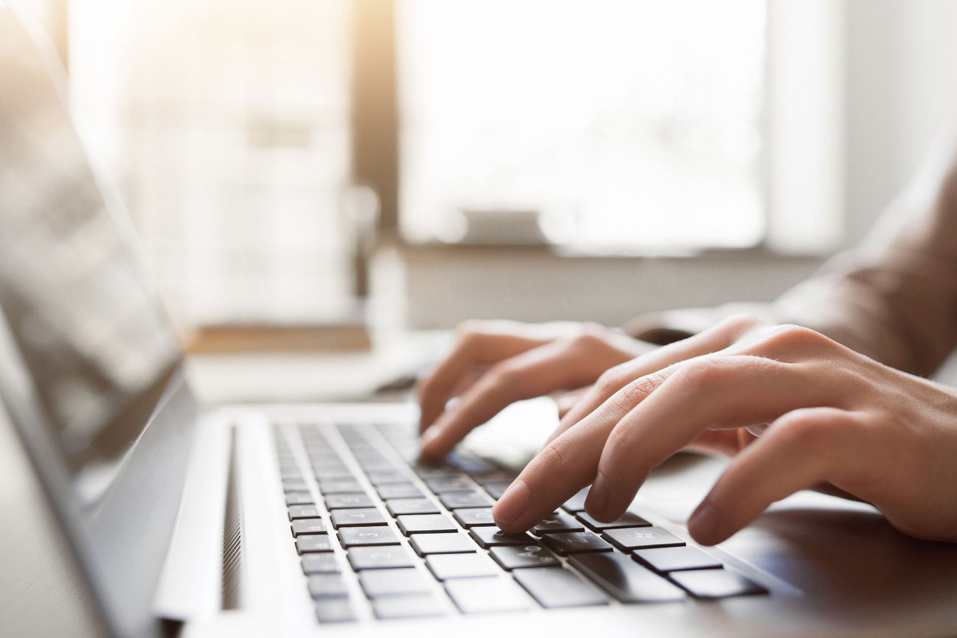 A person is typing on a laptop computer.