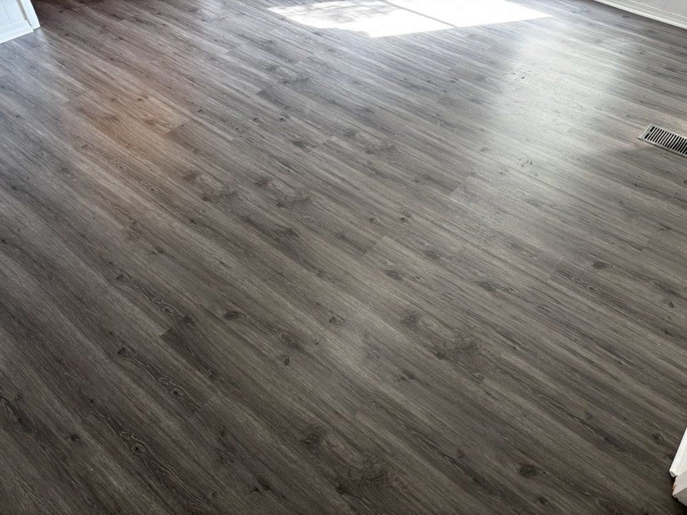 Gray wood-look flooring with sunlight reflecting on the surface