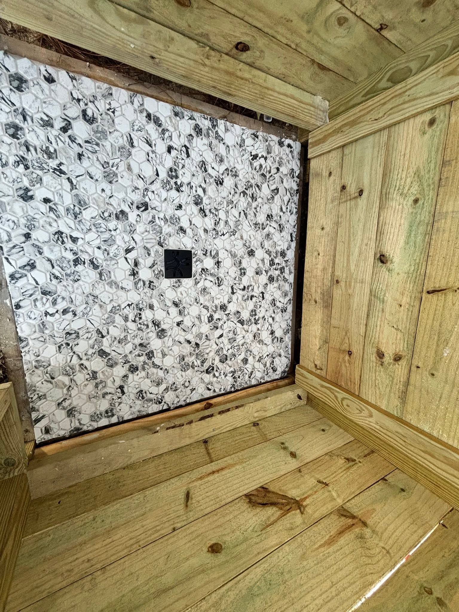 Wooden enclosure with a speckled white panel and a small black square in the center.