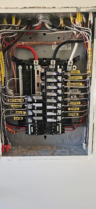 A close up of a electrical panel with a lot of wires coming out of it.