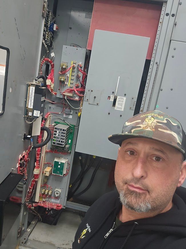 A man wearing a hat is standing in front of a machine.