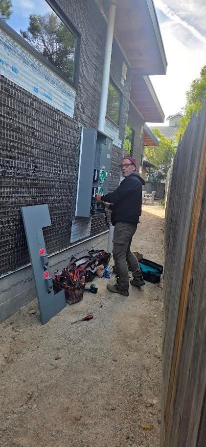 A electrical box is hanging on a wooden wall.