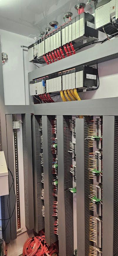 A close up of an electrical box with a lot of wires coming out of it.