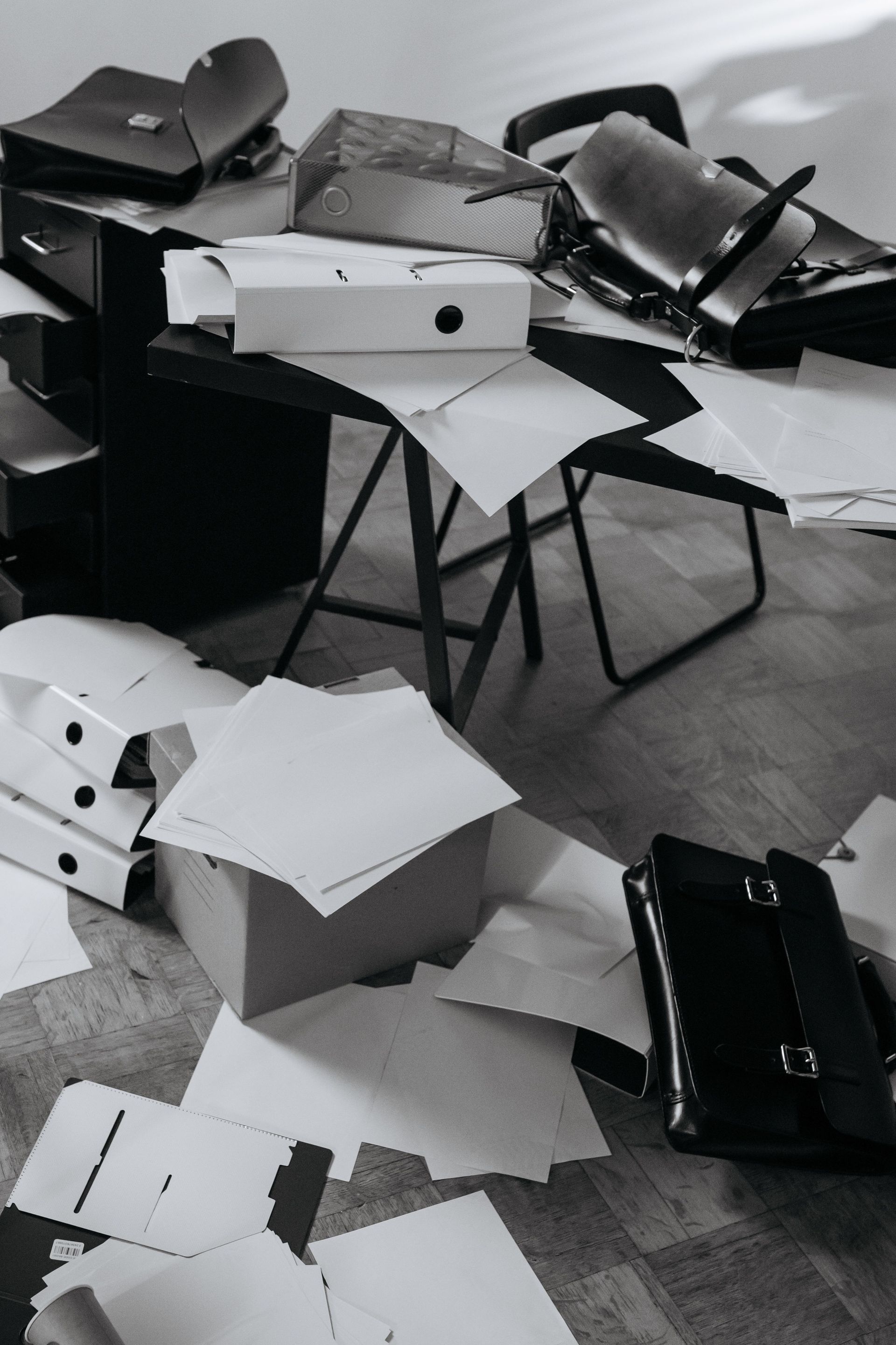 Scattered white and black cardboard pieces on the floor around a small table and chairs in a room