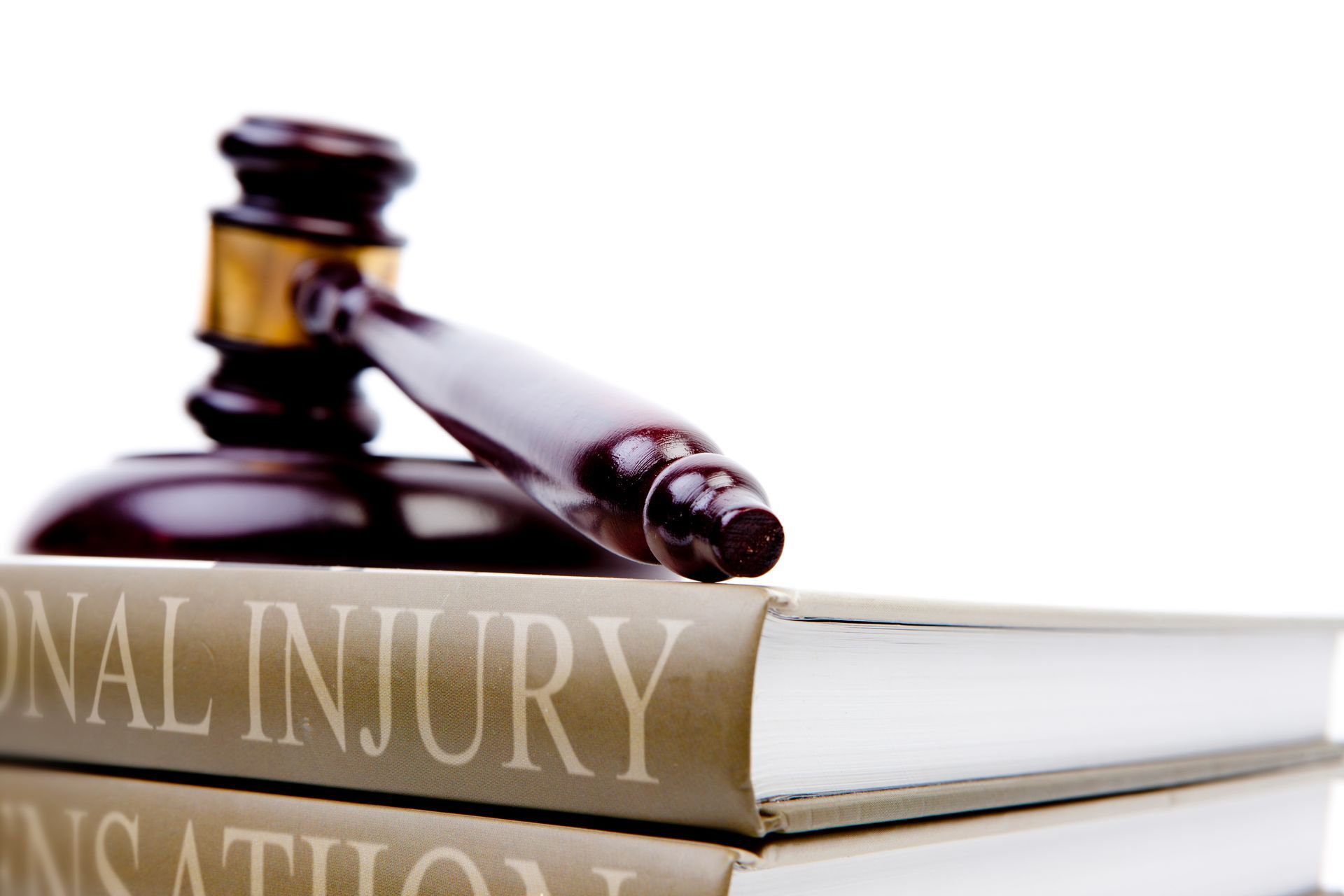 Gavel resting on a law book labeled PERSONAL INJURY. White background.