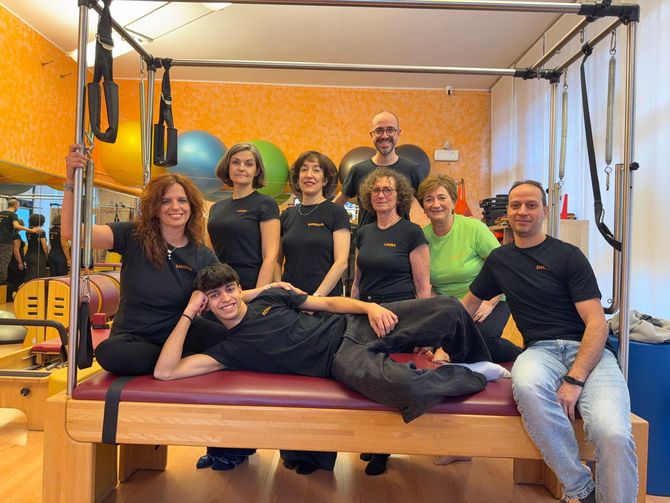 Gruppo di persone in posa in uno studio di pilates.