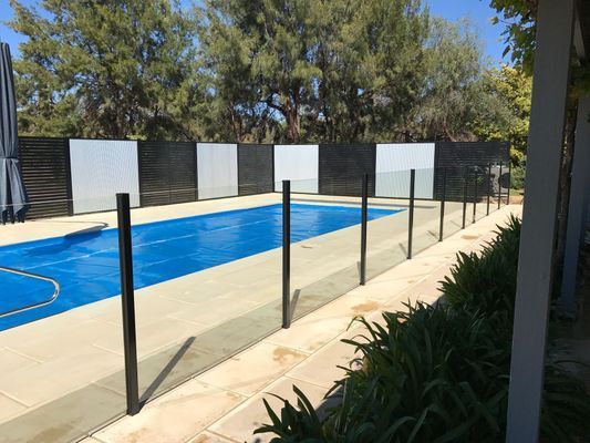 A large swimming pool surrounded by a glass fence.