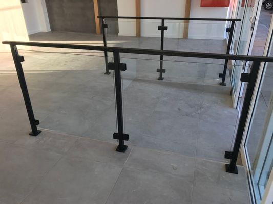 A staircase with a black railing and a glass railing