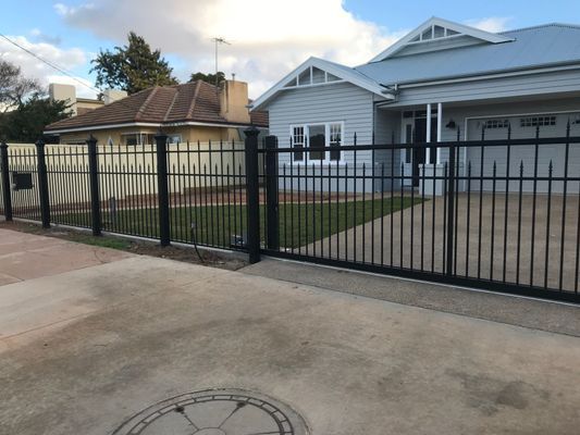 A white house with a black fence in front of it