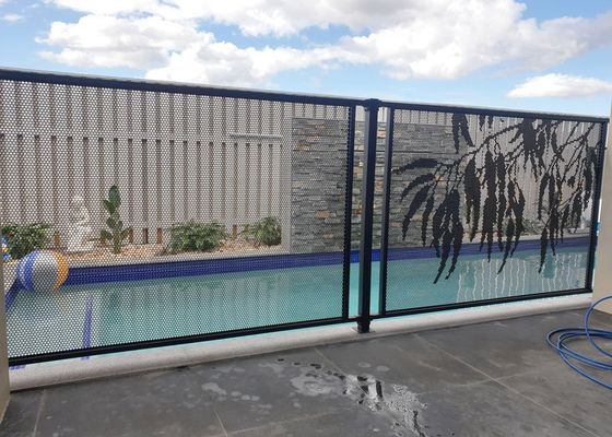 A fence surrounds a swimming pool with a statue in the background.