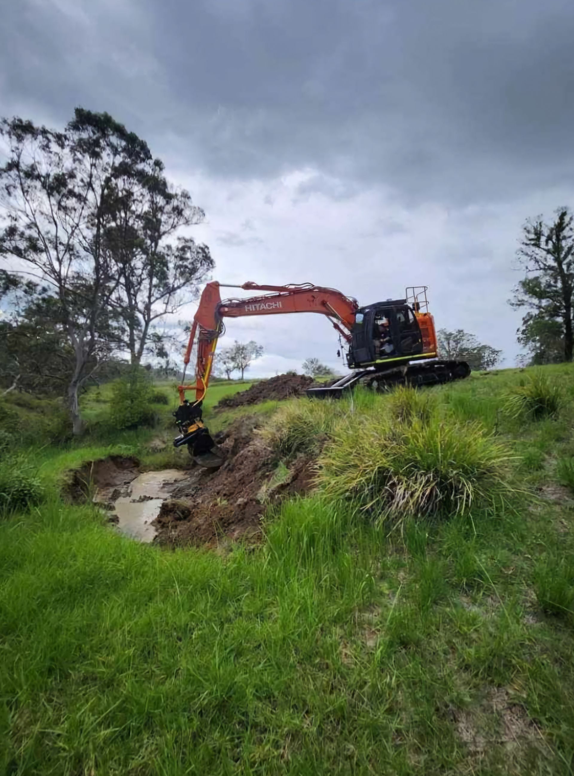 orange digger, digging a hole for dam construction— CHT Excavation and Hire In Wherrol Flat NSW