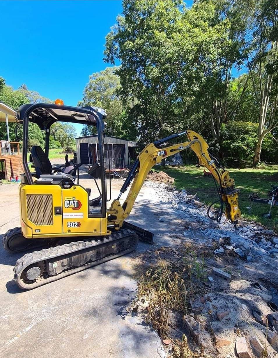 Iron Grate Of A Drainage Channel On A Landscape With Pebbles And Green Grass — CHT Excavation and Hire In Wherrol Flat NSW