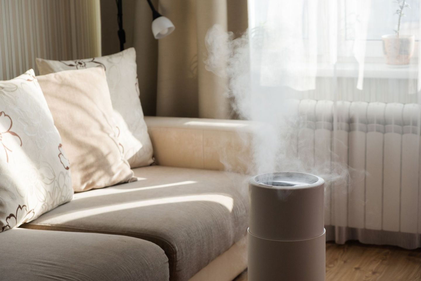 A humidifier is sitting on a couch in a living room.