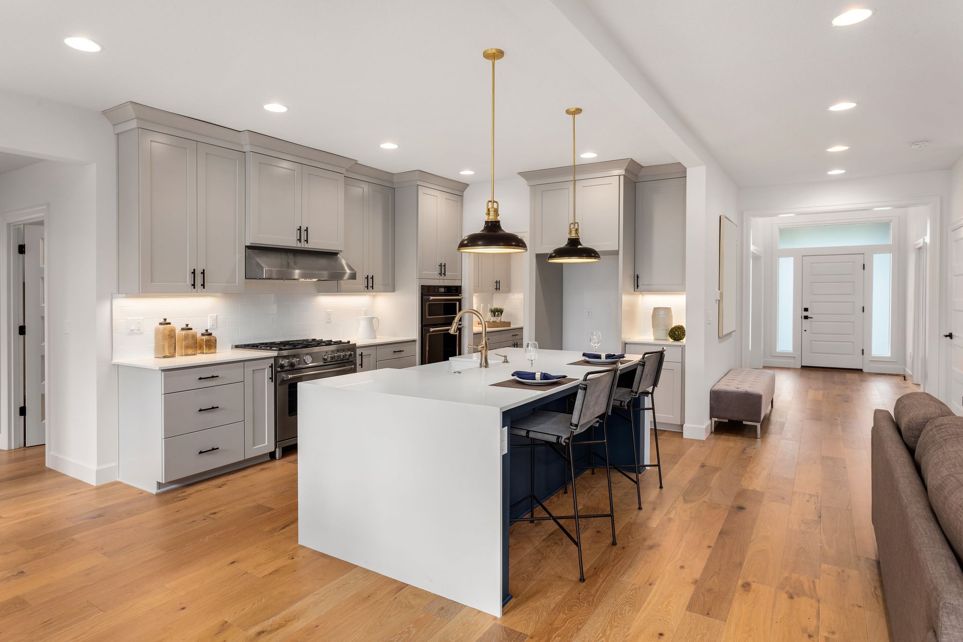 A kitchen with a large island in the middle of it and hardwood floors.