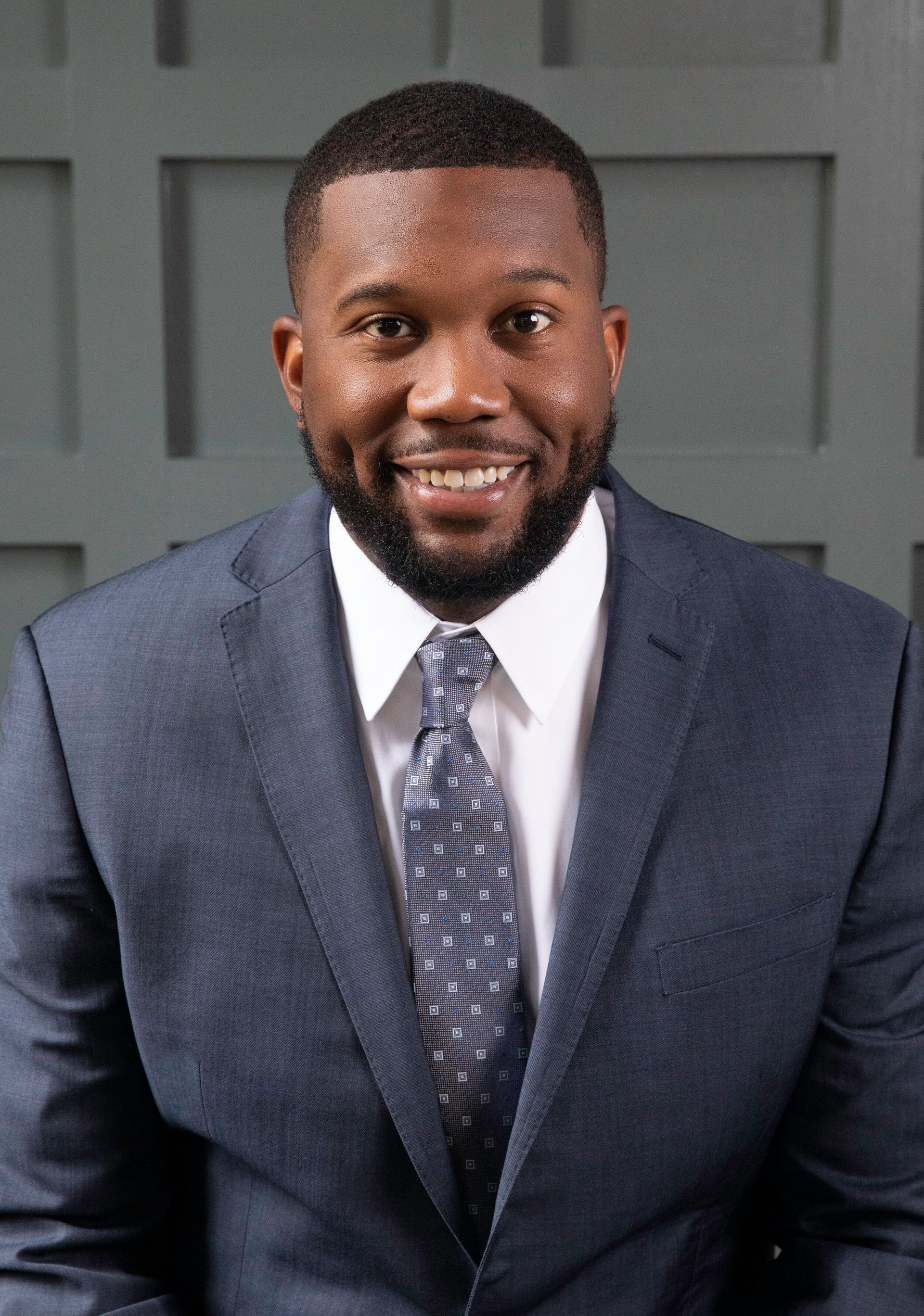 A man in a suit and tie is smiling for the camera.