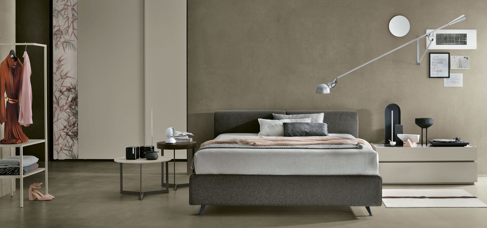 Una camera da letto con un letto grande e una lampada sul muro