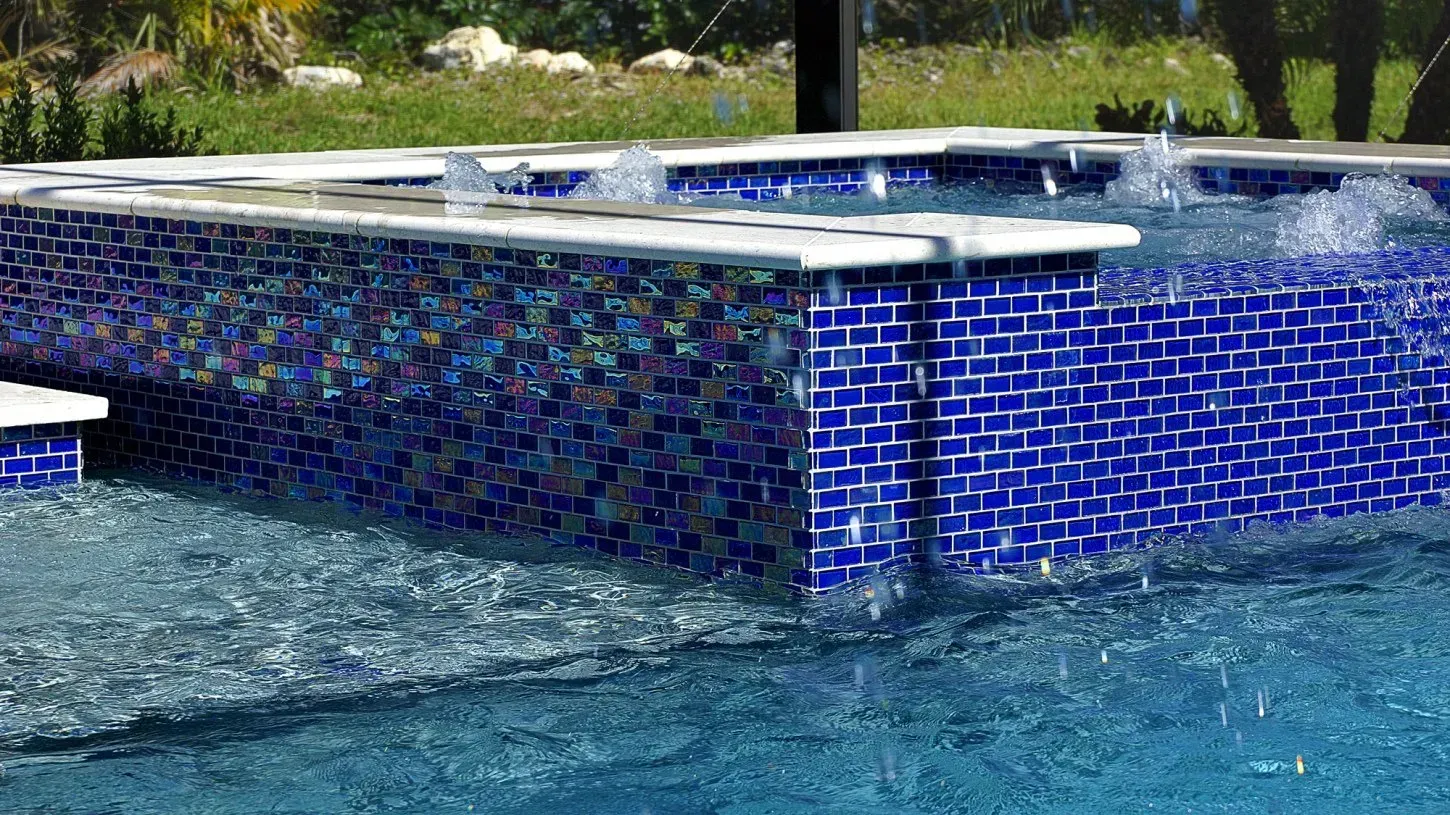 Blue tile pool with water fountain feature; clear, blue water.