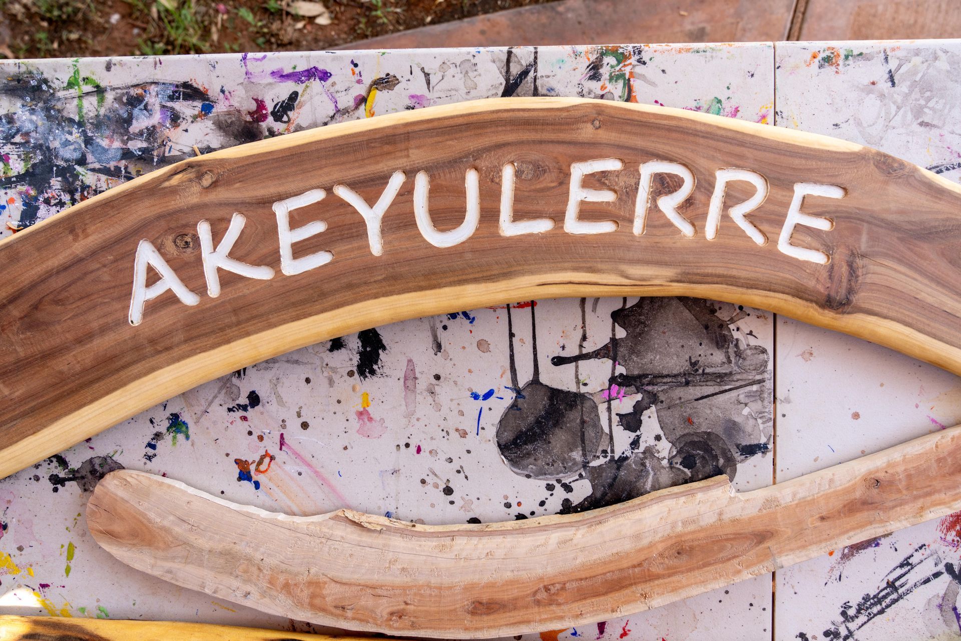 A curved wooden sign with the word 