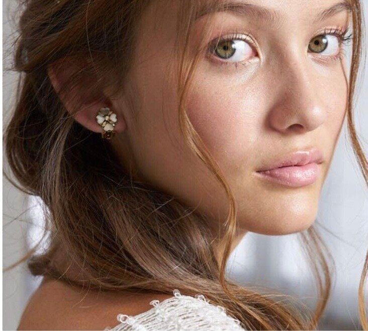 A close up of a woman 's face wearing earrings