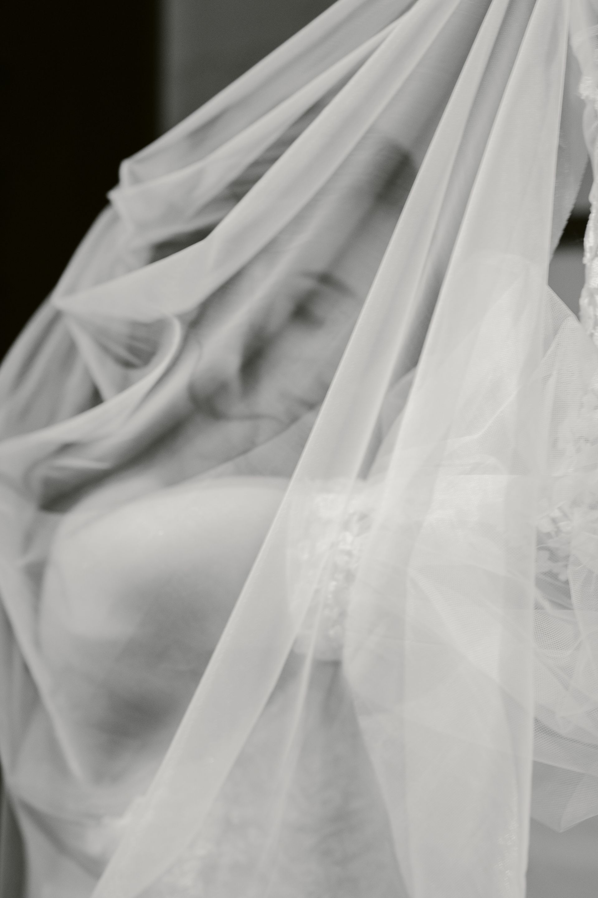 A black and white photo of a statue covered in white cloth.