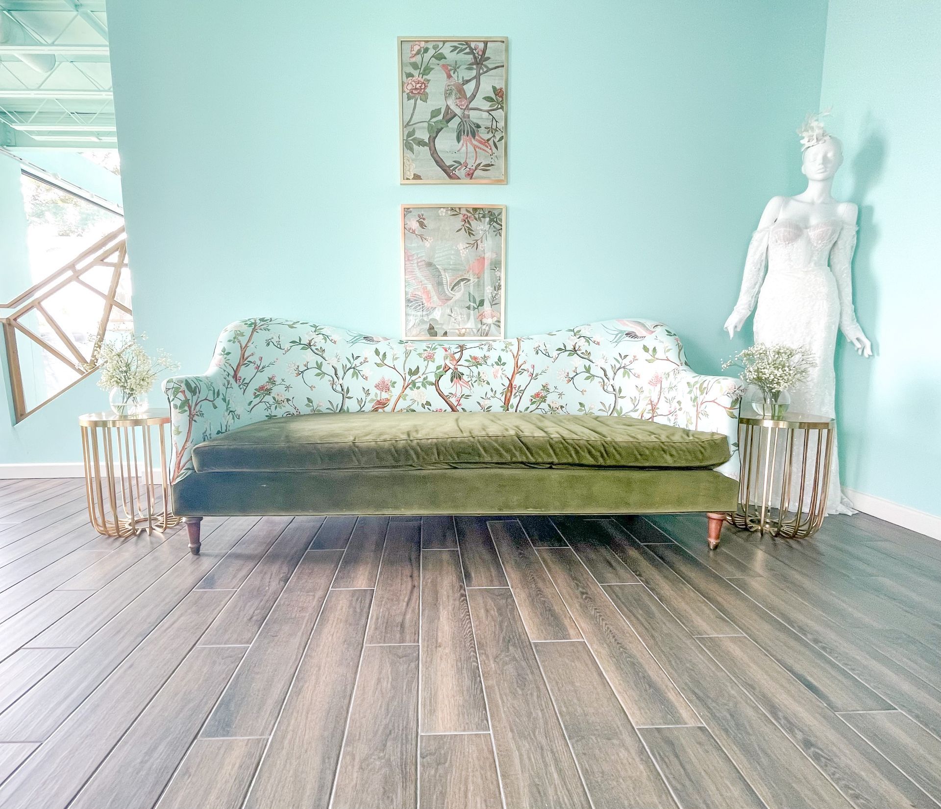 A living room with a green couch and a mannequin