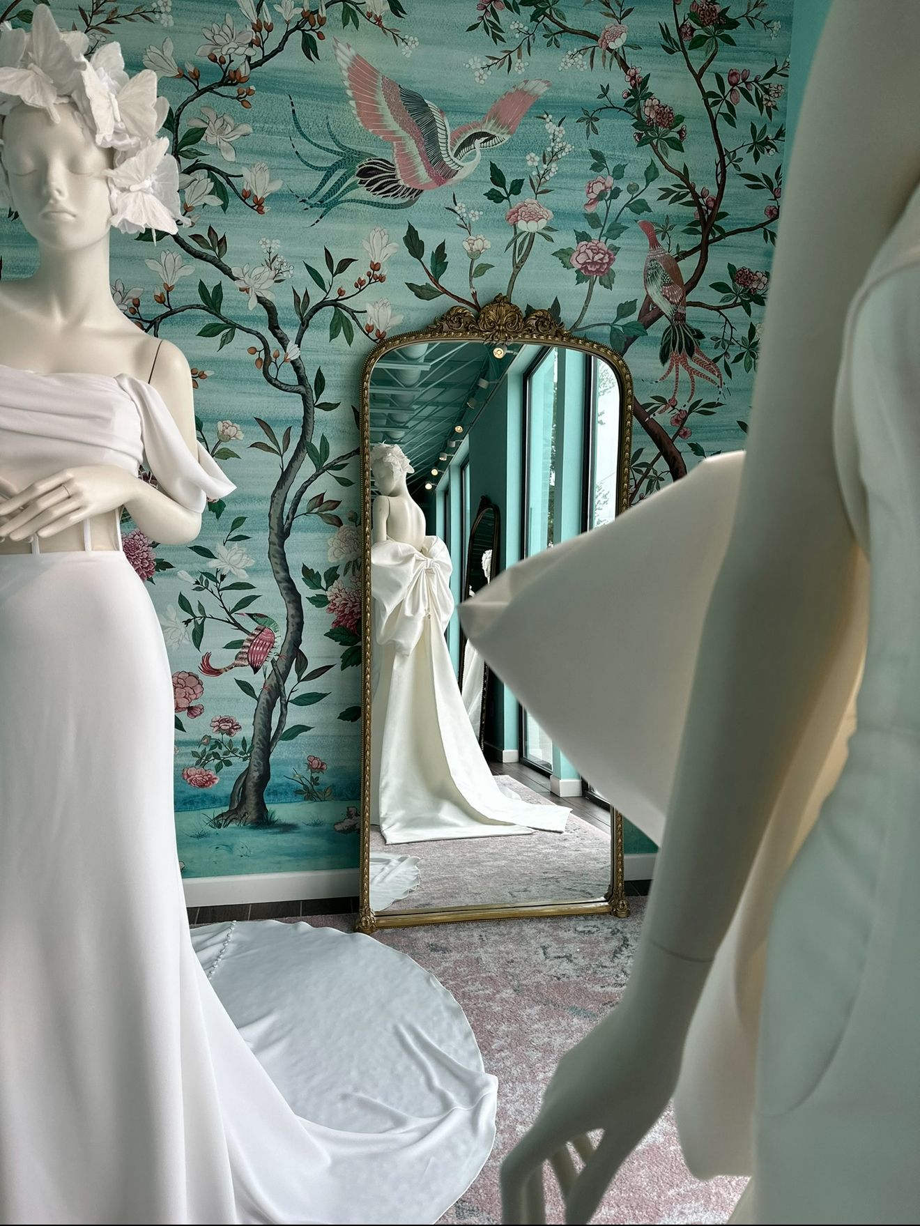 A woman in a white dress is standing in front of a mirror