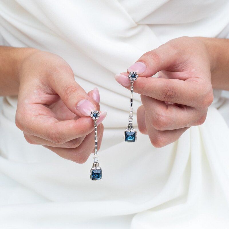 A woman is holding a pair of earrings in her hands
