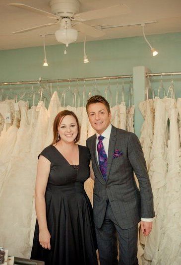 A man in a suit and tie is standing next to a woman in a black dress.
