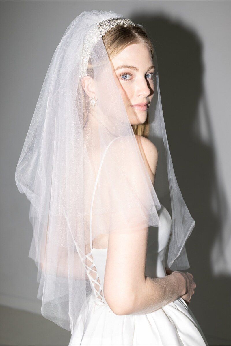 A woman in a wedding dress is wearing a veil.