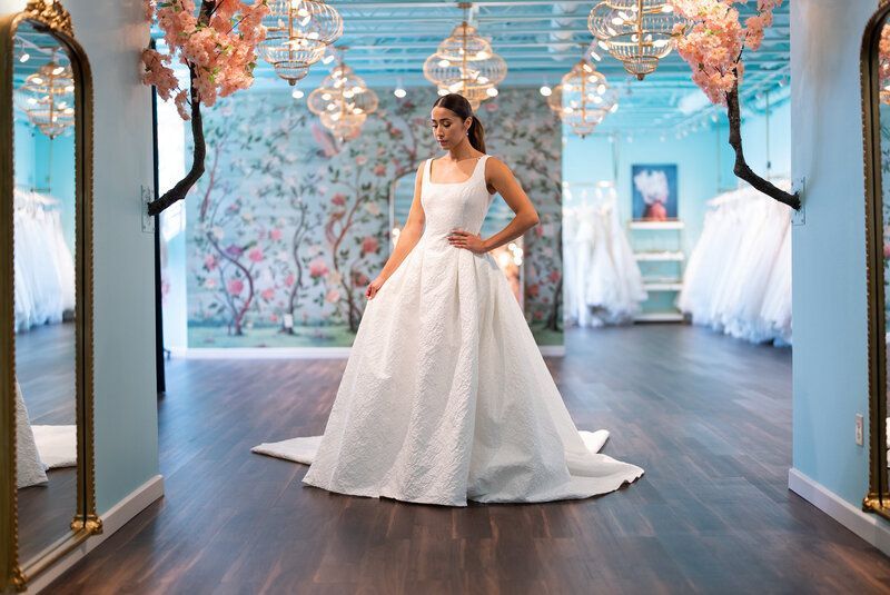 A woman is trying on a wedding dress in a bridal shop.