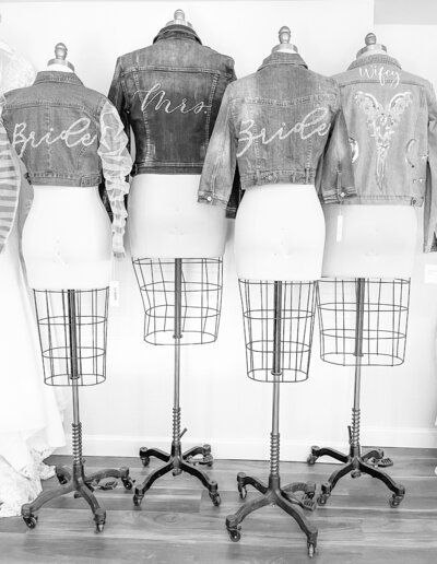 A black and white photo of four mannequins wearing denim jackets.
