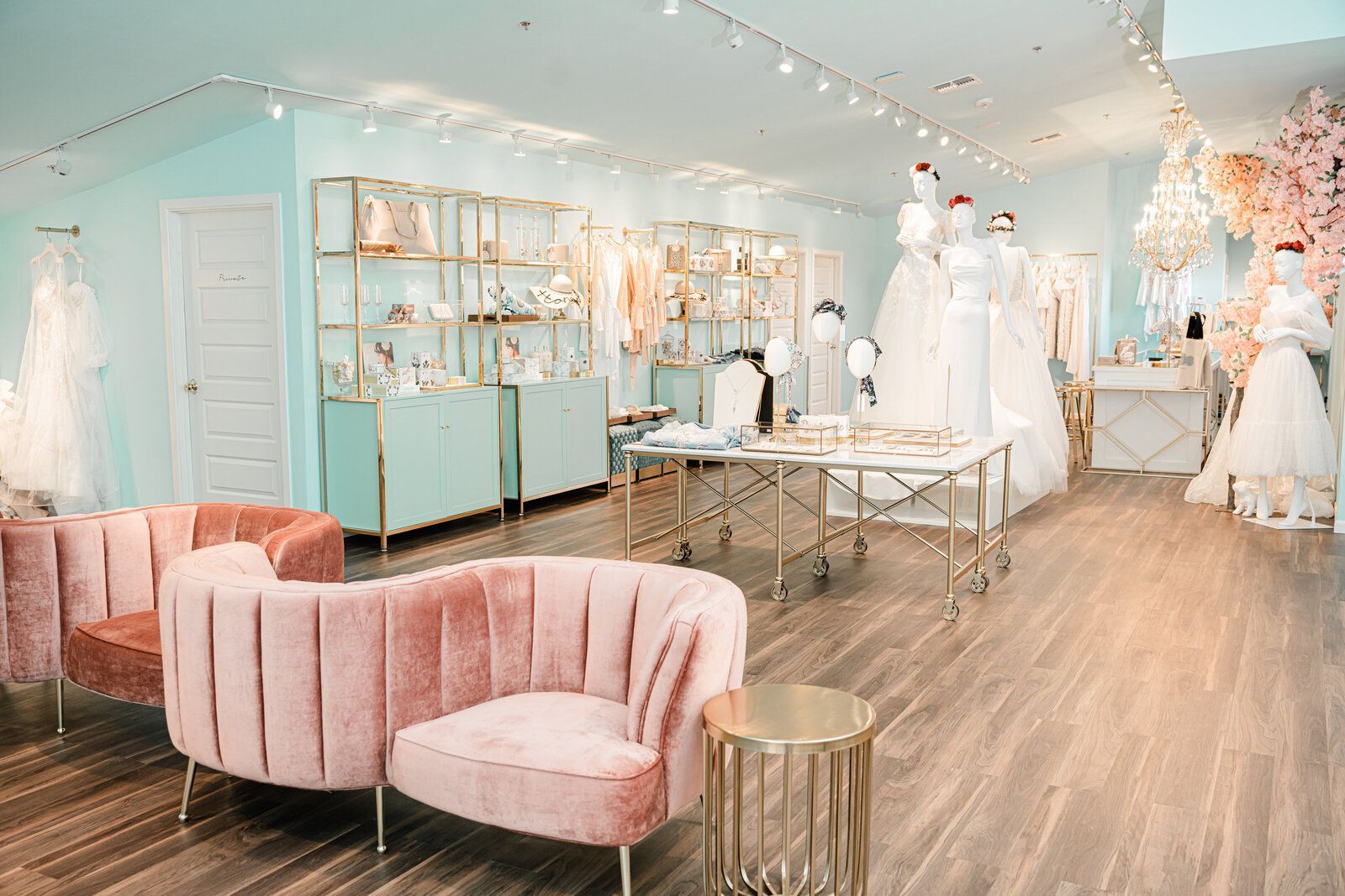 A wedding dress store with a pink couch and chairs.