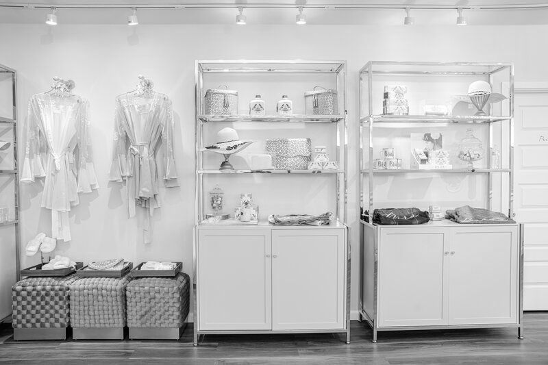 A black and white photo of a store with shelves and cabinets.