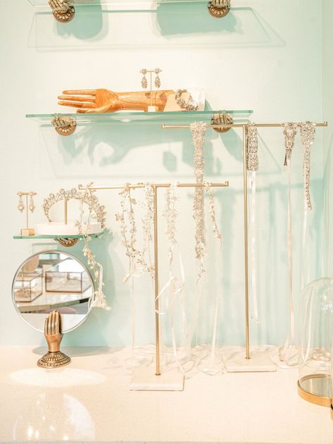 A display of jewelry in a store with shelves and a mirror.