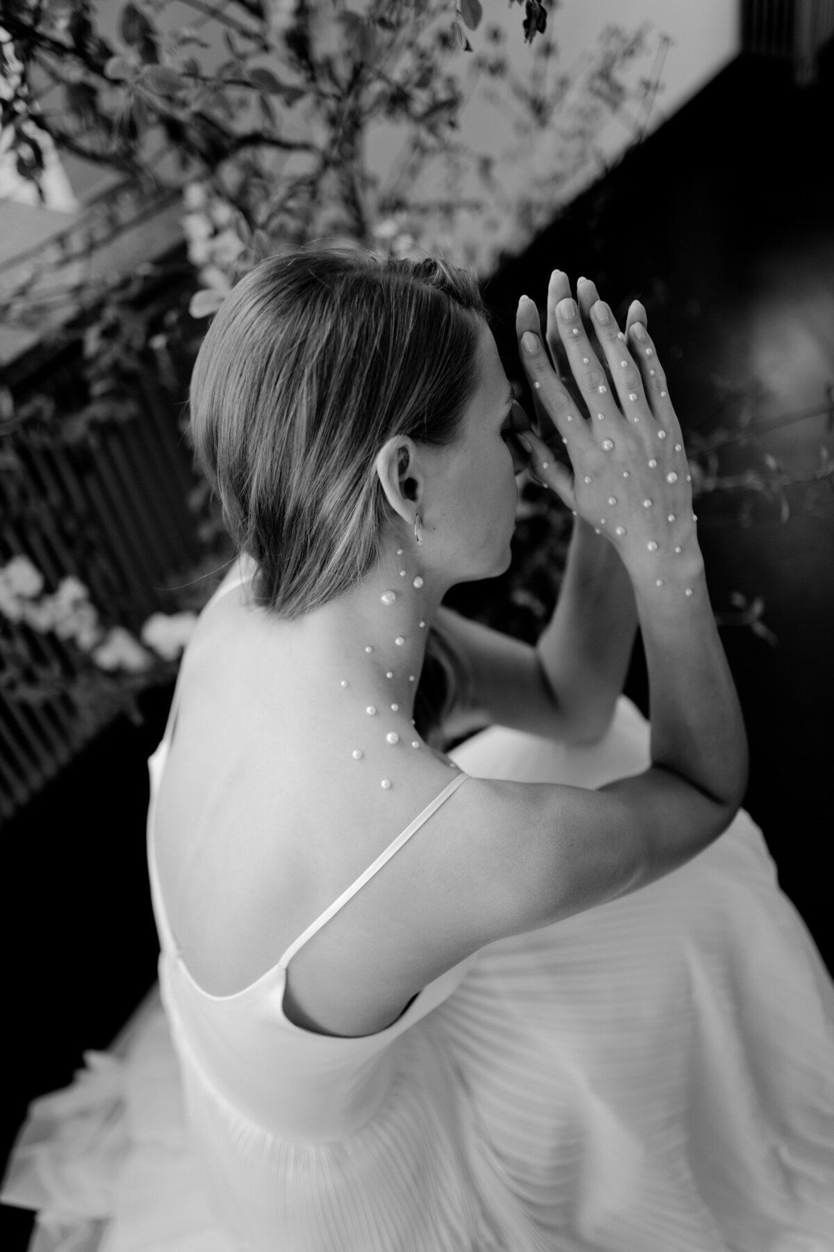 A black and white photo of a woman in a wedding dress and gloves.