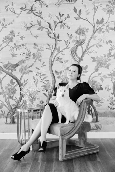 A woman is sitting in a chair with a white cat on her lap