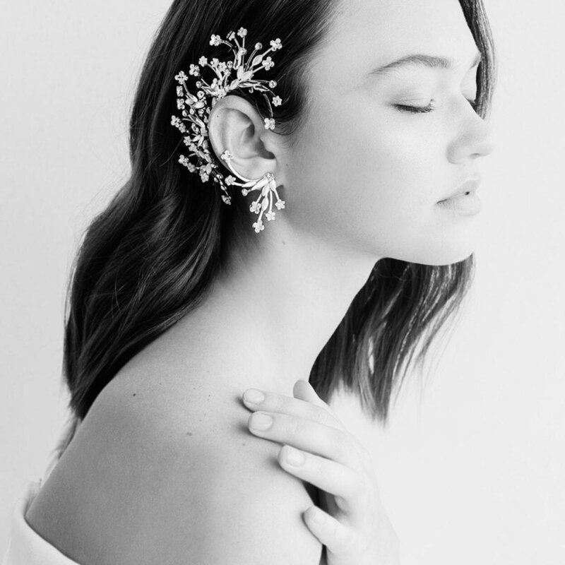 A black and white photo of a woman wearing earrings