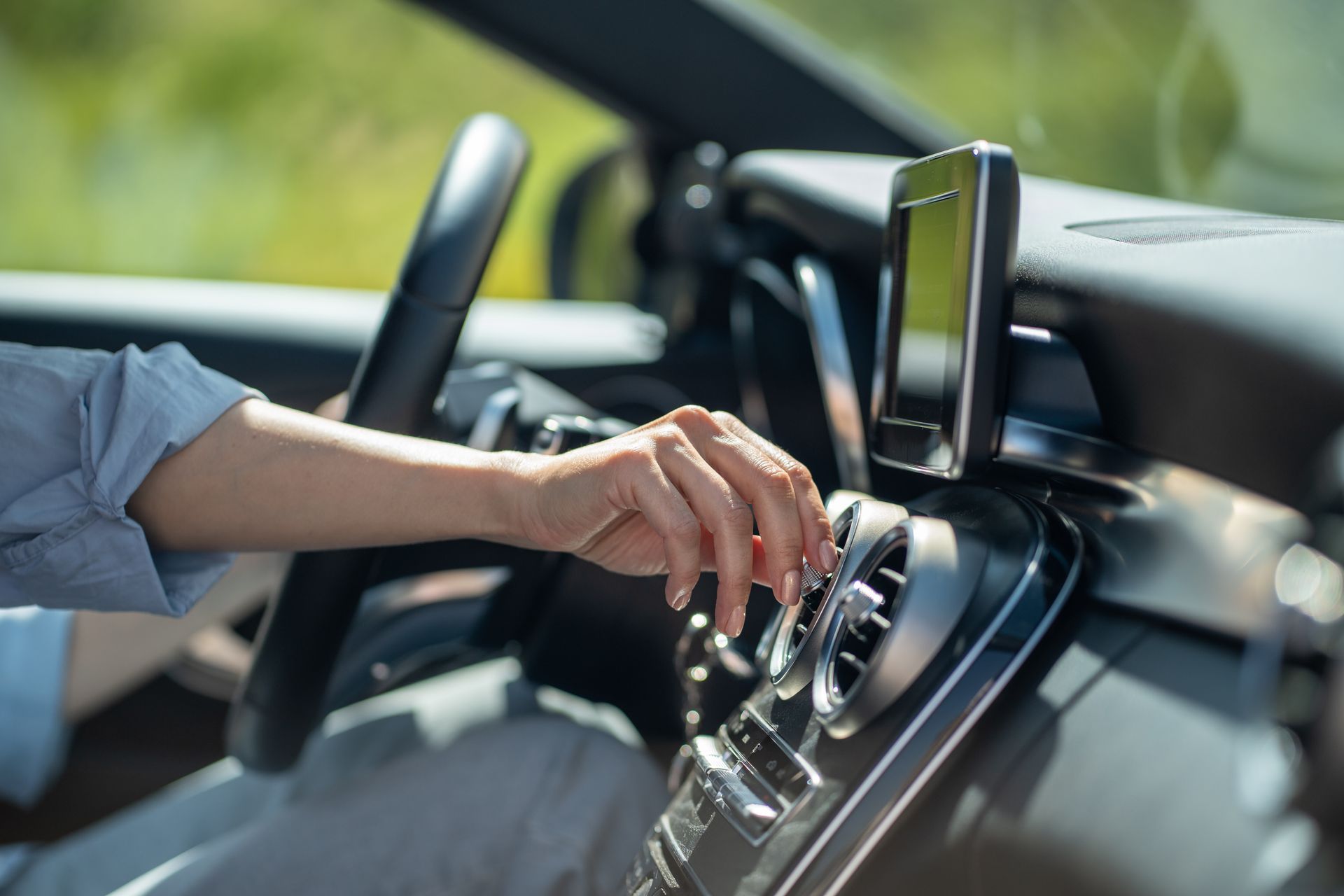 Person adjusting car air vent.