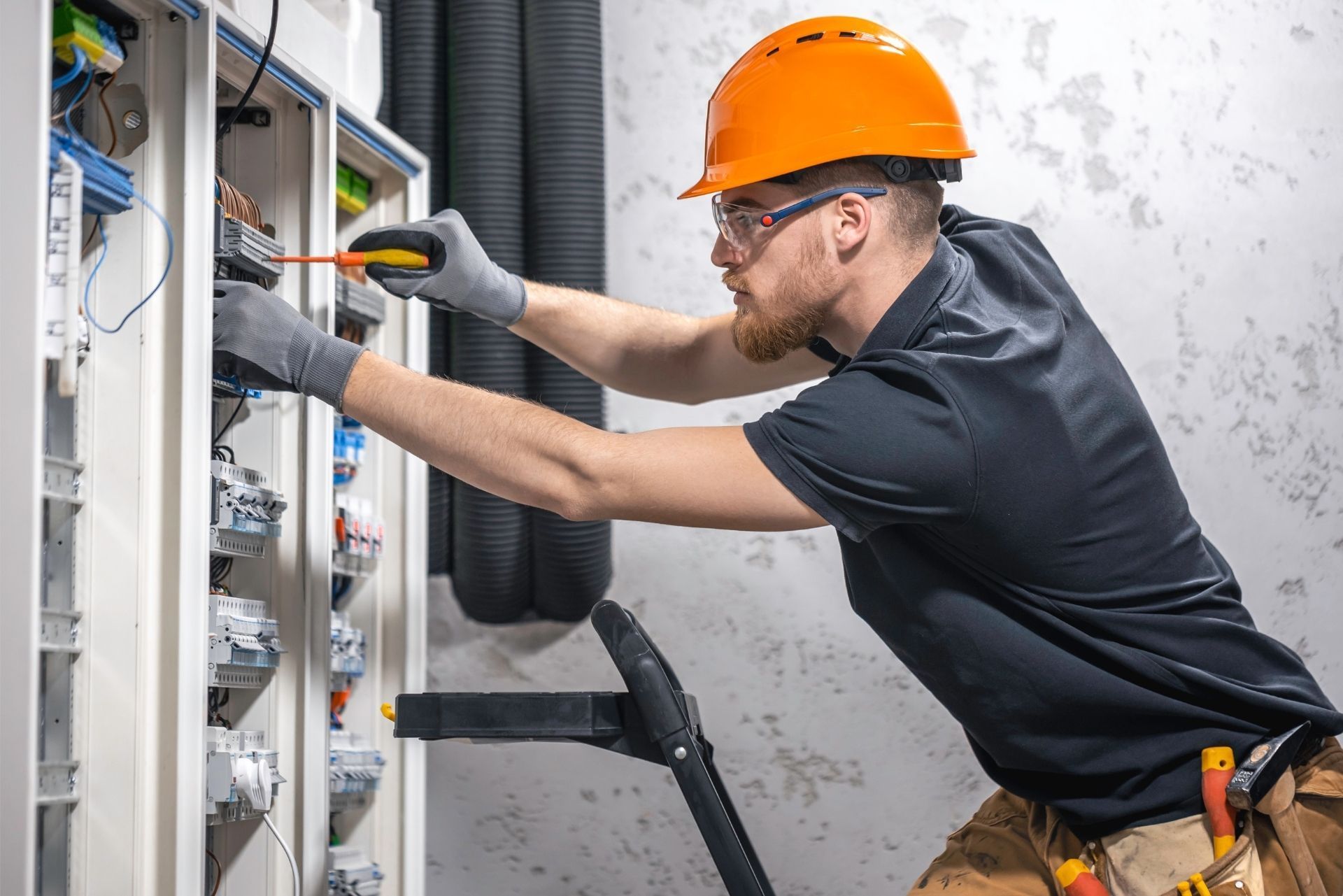 HVAC technician wearing mask and hard hat, working on AC units on a rooftop. HVAC technician wearing mask and hard hat, working on AC units on a rooftop.